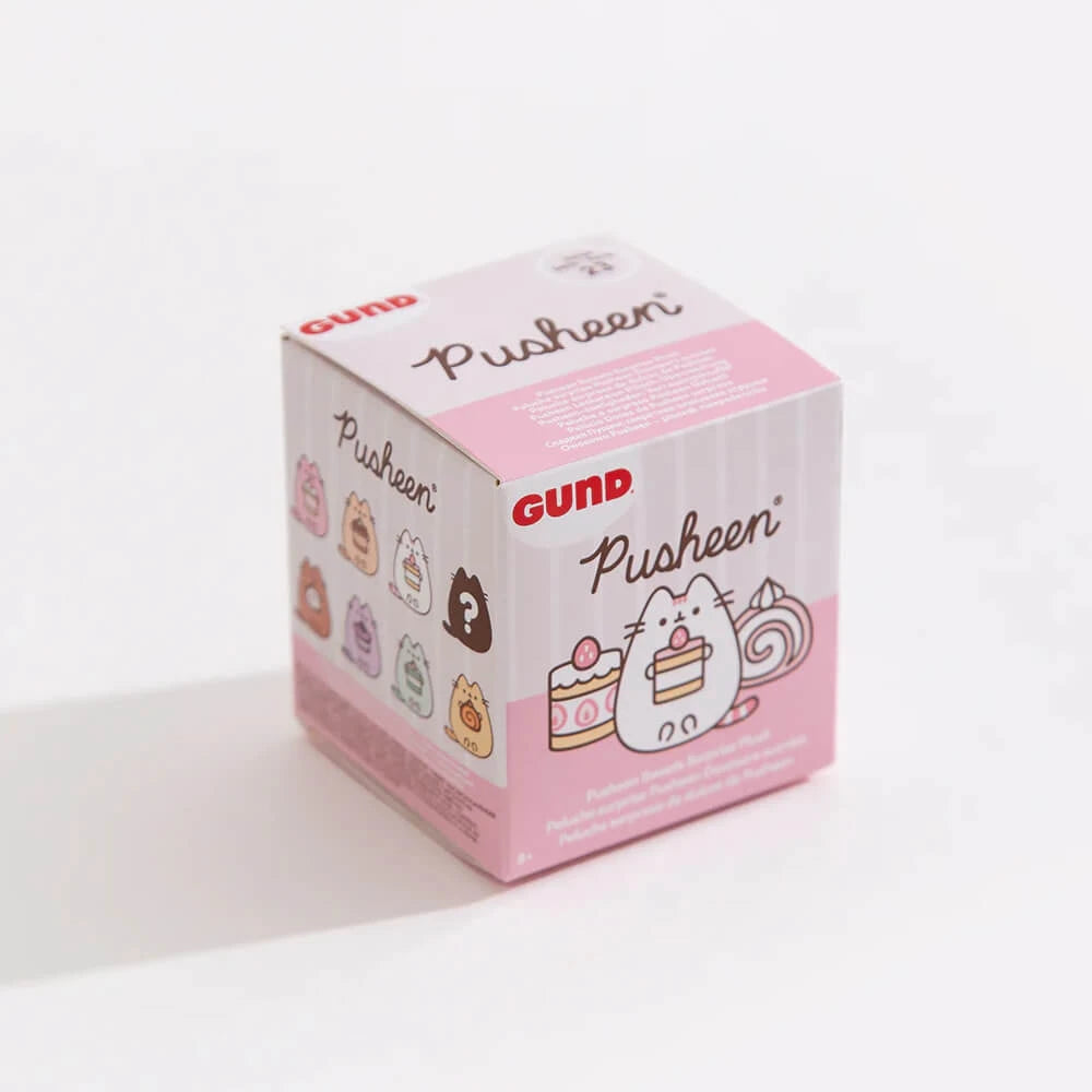A square pink and white "Pusheen Blind Box - Sweets Series" by Pusheen, featuring dessert-themed illustrations of Pusheen and cake, with images of collectible figures on the side.
