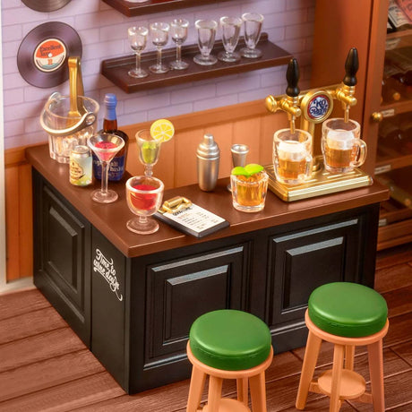 The Rolife Leisurely Cheers Bar - DIY Plastic Mini House by Rolife features a mini bar set with drink taps, cocktails, and stools on a brown counter. Vinyl records decorate the walls, enhanced by cozy mood lighting.