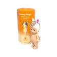 A small figurine dressed in a unicorn outfit stands next to its orange packaging, labeled "Sonny Angel Animal Version 3 Series." This collectible figure, typically available in a blind box, is ideal for enthusiasts looking to enhance their delightful Sonny Angel collection.