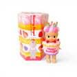 Birthday cake-themed collectible figure with pink frosting hat and orange candle toppers