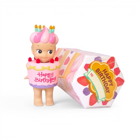 The Sonny Angel Happy Birthday Cake Gift by Sonny Angel features a charming toy figure dressed in a birthday cake costume adorned with candles, housed in a festive "Happy Birthday" box. As part of the delightful Birthday Cake Series, it offers an exciting surprise experience similar to uncovering hidden treasures in a Blind Box.