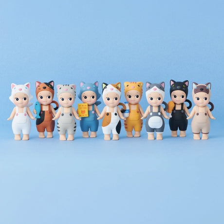 Nine toy figures from the Sonny Angel Cat Life Series by Sonny Angel, each outfitted in cat-themed costumes with a variety of colorful patterns, charmingly pose against a light blue backdrop.