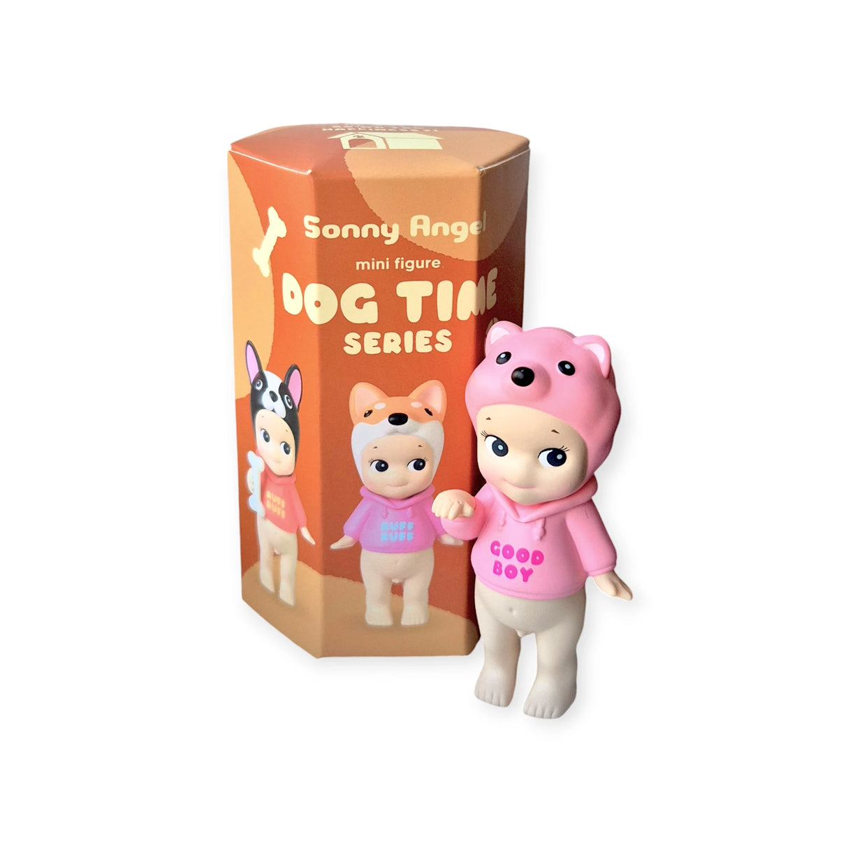 A small, collectible Sonny Angel figure from the "Dog Time Series," dressed in a pink "Good Boy" dog costume, is displayed alongside its packaging, celebrating adorable dog breed figures.