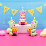 Birthday bear figurines with cake, candle, and Happy Birthday bunting