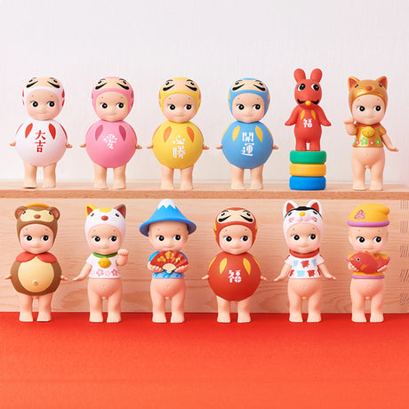 Multiple blind box collectible figures in festive lucky outfits, lined up
