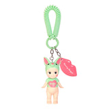 This charming keychain by Sonny Angel features a doll from the Kiss Kiss Series in a green outfit with bunny ears, a "KISS" pink heart on its chest, and a lip-shaped tag reading "Sonny Angel." Ideal for fans of Sonny Angel Blind Box figurines.