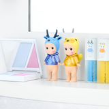 Two Makeup Angel figures on display with boxed mini collectibles behind them