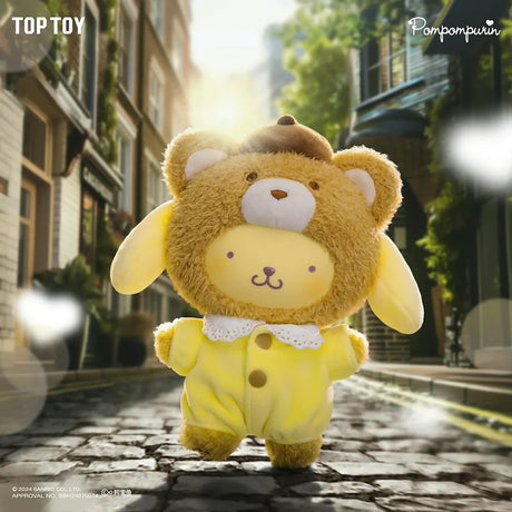 Plush toy wearing a brown bear hat and yellow outfit standing on a cobblestone street with sunlight filtering through trees