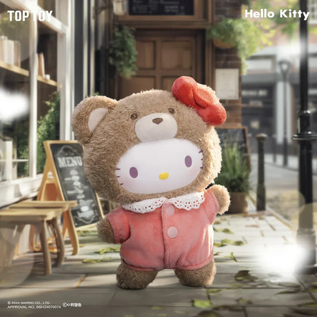 Hello Kitty plush dressed in a brown bear costume with red bow standing on a sunlit outdoor café walkway