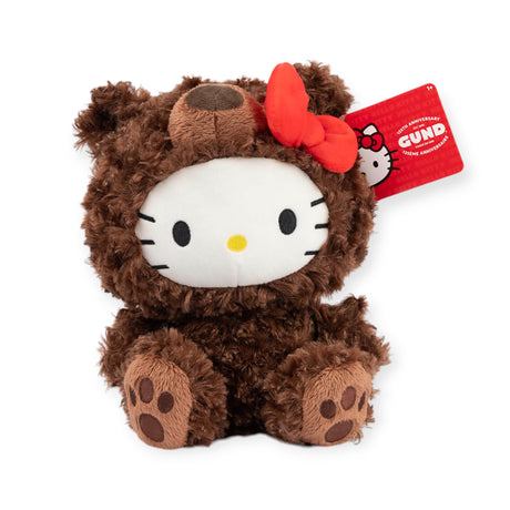 This delightful Hello Kitty x Gund - Philbin Bear Plush - Limited Edition showcases the iconic Hello Kitty with her signature white face and whiskers, dressed in an adorable brown bear suit with a red bow. It's a perfect addition for collectors of GUND who appreciate unique and whimsical designs.