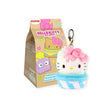 The Hello Kitty Snack Plush - Blind Bag features a charming plush cupcake keychain with a pink bow, nestled in front of a decorated box adorned with cartoon characters and colorful stars. A delightful addition to any Hello Kitty keychains collection.