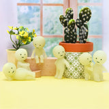 Smiski Series 1 Blind Box figures glow in the dark as they pose around a cactus pot and plant, with a window backdrop.