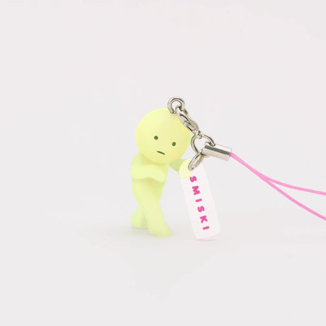 Lemon-green Smiski keychain figure with pink lanyard strap and small charm tag