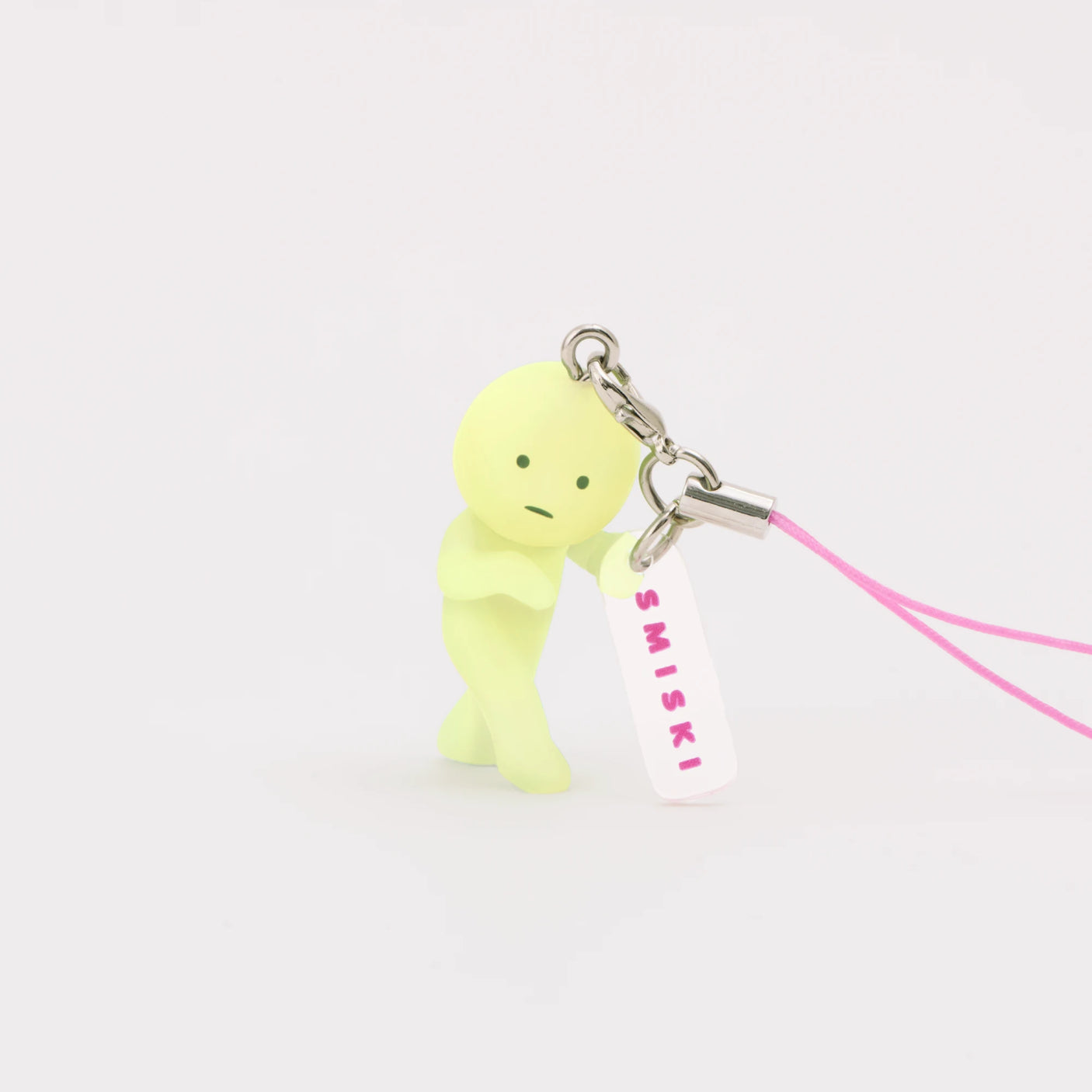 Light green Smiski strap keychain figure with pink cord and hanging SMISKI tag