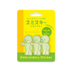 Three light green embroidered Smiski characters on yellow card labeled for iron-on or sticker use