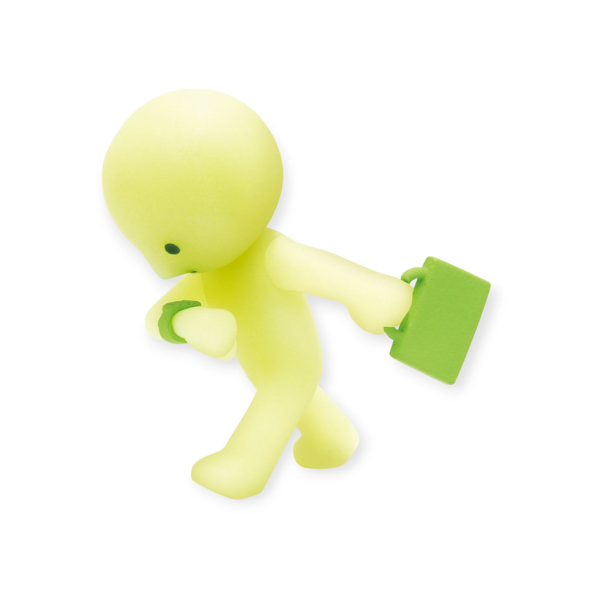 A charming, small, yellow Smiski At Work Series figure featuring a humanoid design is holding a green briefcase and gesturing with its other hand against a plain white background. This delightful character can be discovered in the exciting surprise of a Smiski At Work Series - Blind Box and also features glow-in-the-dark capabilities.