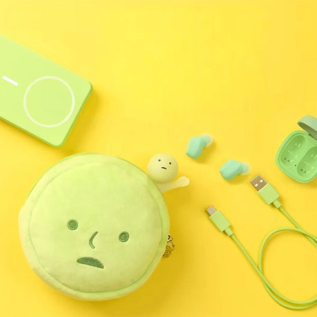 Round pale green plush pouch with simple embroidered face and matching green wireless earbuds with charging case and cable