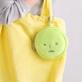 Round green cushion pouch keychain with sad face, zipper, and metal keyring clip