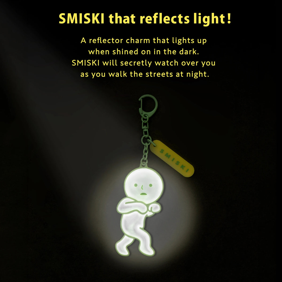 Reflective green Smiski charm glowing in low light on keychain