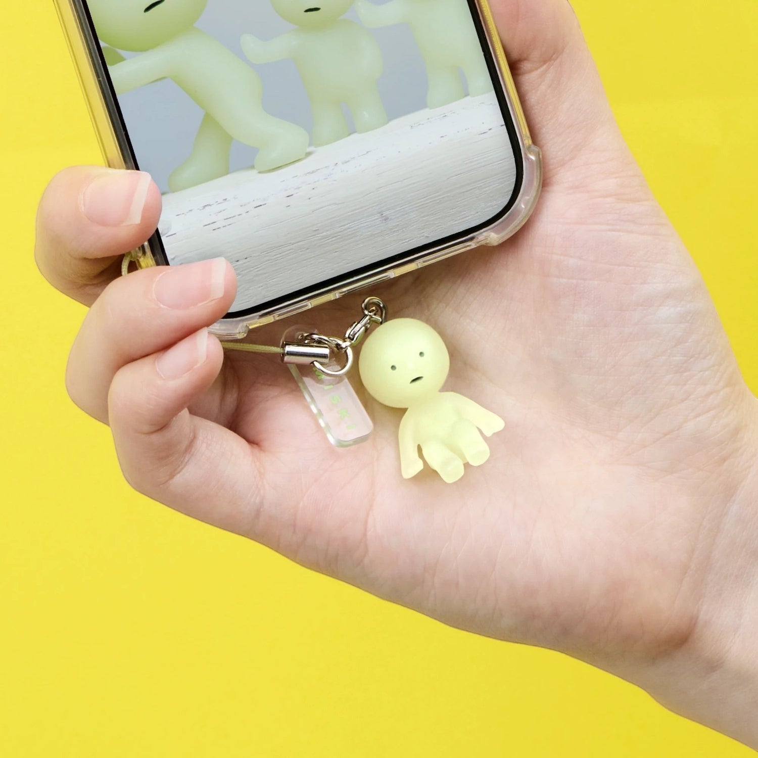 Small green character keychain with metal clasp in a hand