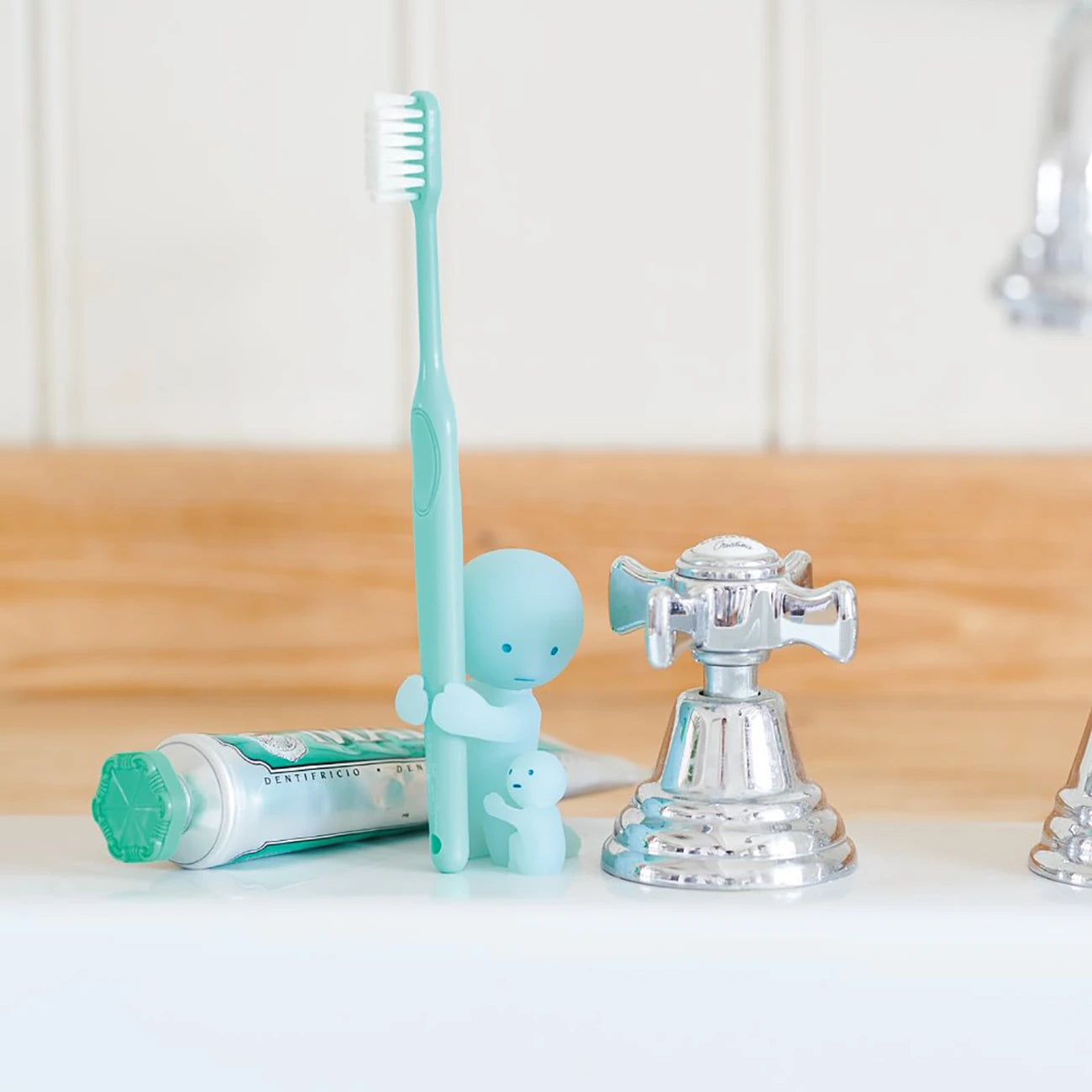 The Smiski Toothbrush Holder - Hugging Figure, a delightful glow-in-the-dark collectible from Smiski, showcases an adorable design of a character embracing a child. It's ideal for positioning next to the faucet and toothpaste on your bathroom sink.