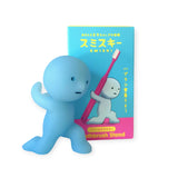 A Smiski Toothbrush Holder - Carrying Figure in blue, crafted from phosphorescent material, featuring packaging that highlights a whimsical character and includes an illustration of a toothbrush.