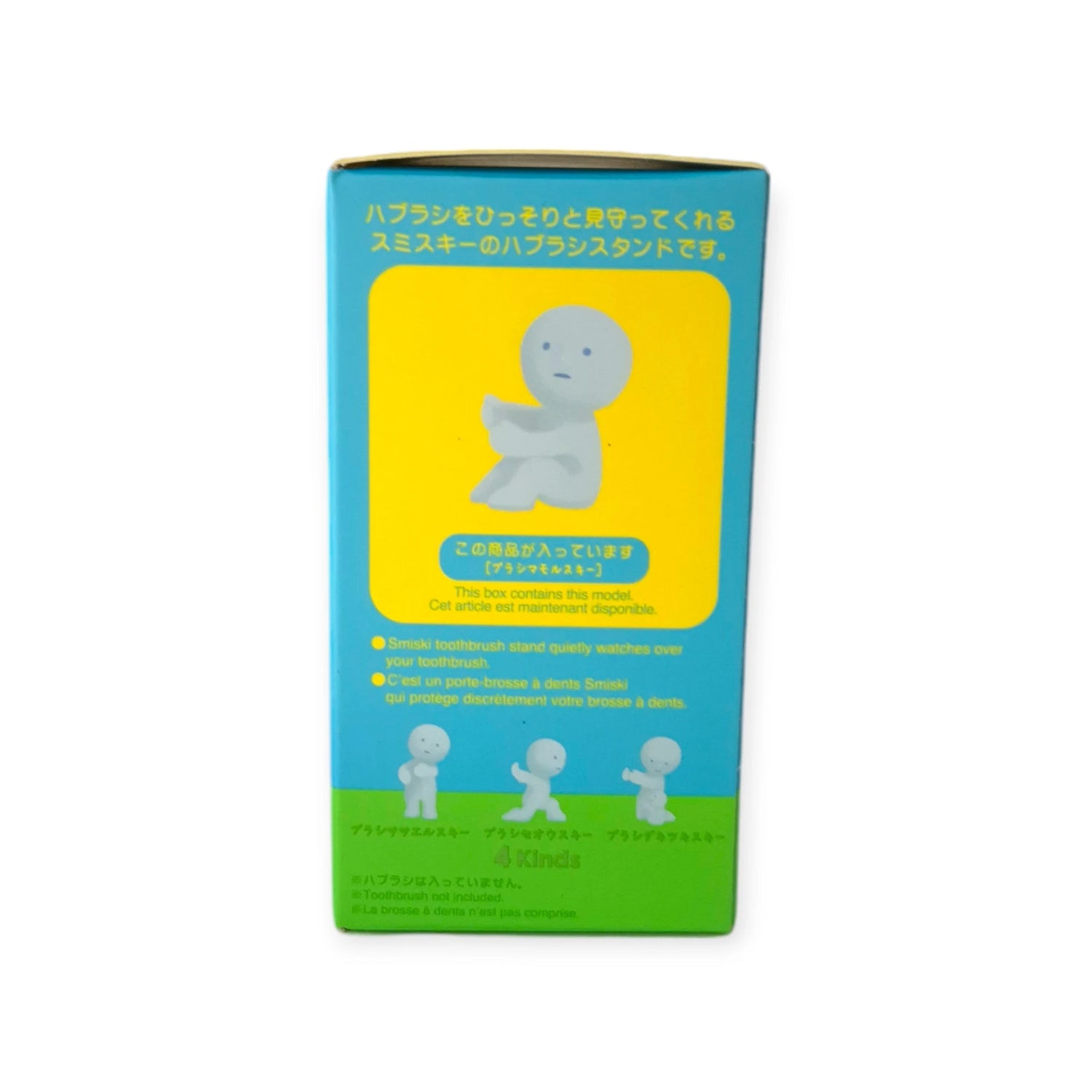 A box showcasing a diminutive white figure seated on a stool, complete with product details and text in multiple languages set against a blue and yellow background. This Glow-in-the-Dark Smiski Toothbrush Holder - Protecting Figure from Smiski not only enhances your bathroom routine but also adds an element of charm.