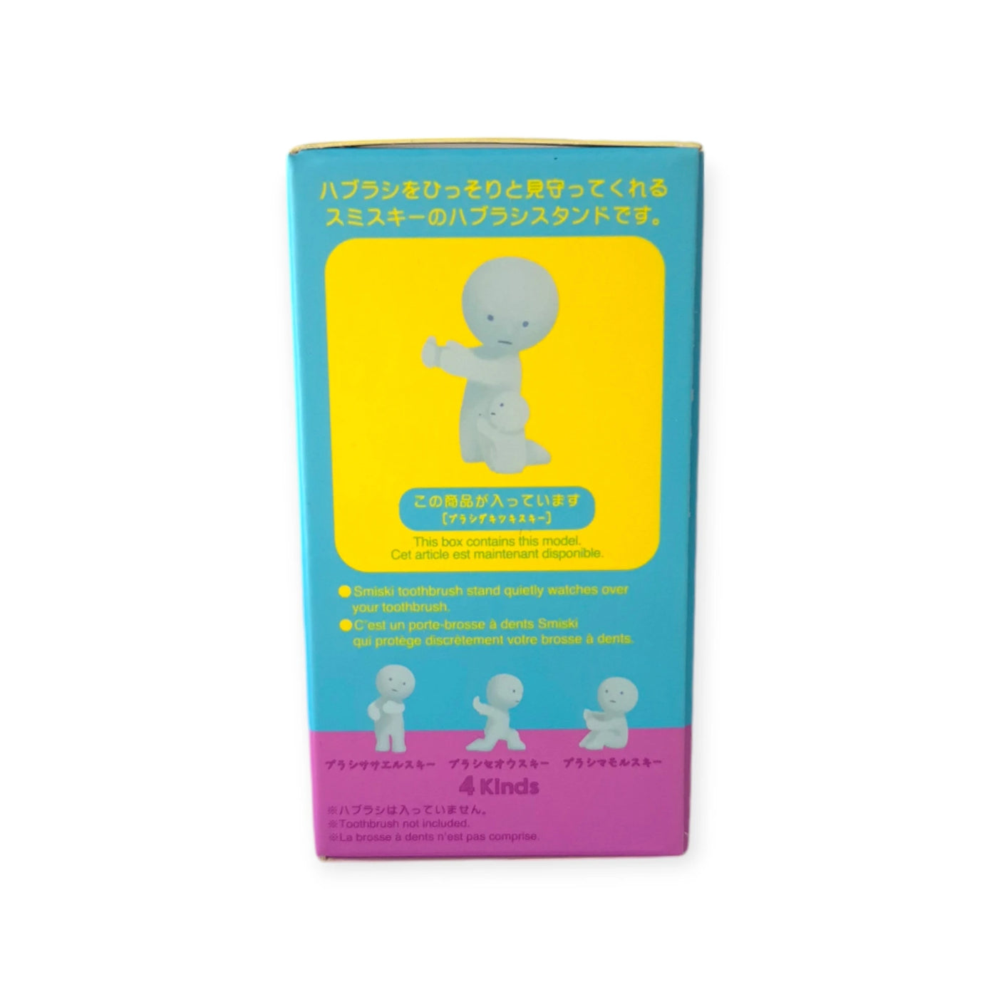 The packaging for the Smiski Toothbrush Holder - Hugging Figure is vibrant, featuring illustrations of a figure holding a toothbrush. This clever design doubles as the Smiski Toothbrush Holder. The package includes product features and details in both Japanese and English, emphasizing its glow-in-the-dark collectible figures.