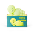 Smiski Touch Light lounging figure, light green, resting on product box