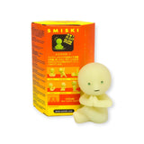 A small figure from the Smiski Yoga Series - Blind Box glows in the dark, sitting serenely with clasped hands in front of its orange packaging, which is adorned with calming yoga poses and illustrations.