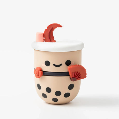 Small beige bubble tea figure with black tapioca pearls, smiling face, red fan, flower, and crescent moon decoration on white background