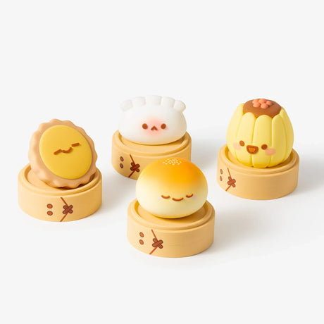 Four Smoko Dim Sum Friends vinyl figures resembling dim sum dishes displayed on bamboo steamers against white background