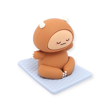 Brown Smoko Hank Yeti figure sitting cross-legged with eyes closed on a textured light blue yoga mat