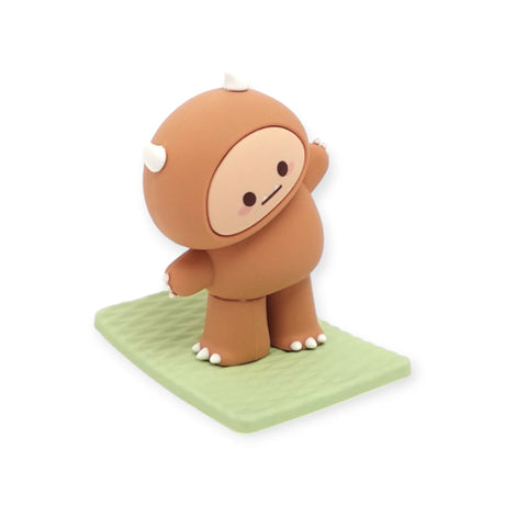Brown Smoko Hank Yeti figure standing with arms stretched on textured light green yoga mat against white background