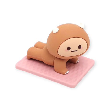Brown Smoko Hank Yeti figure in cobra yoga pose on textured pink mat against white background
