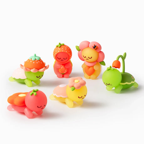 Five colorful Smoko Kawawa Turtle figures dressed in fruit and flower costumes resting on white background