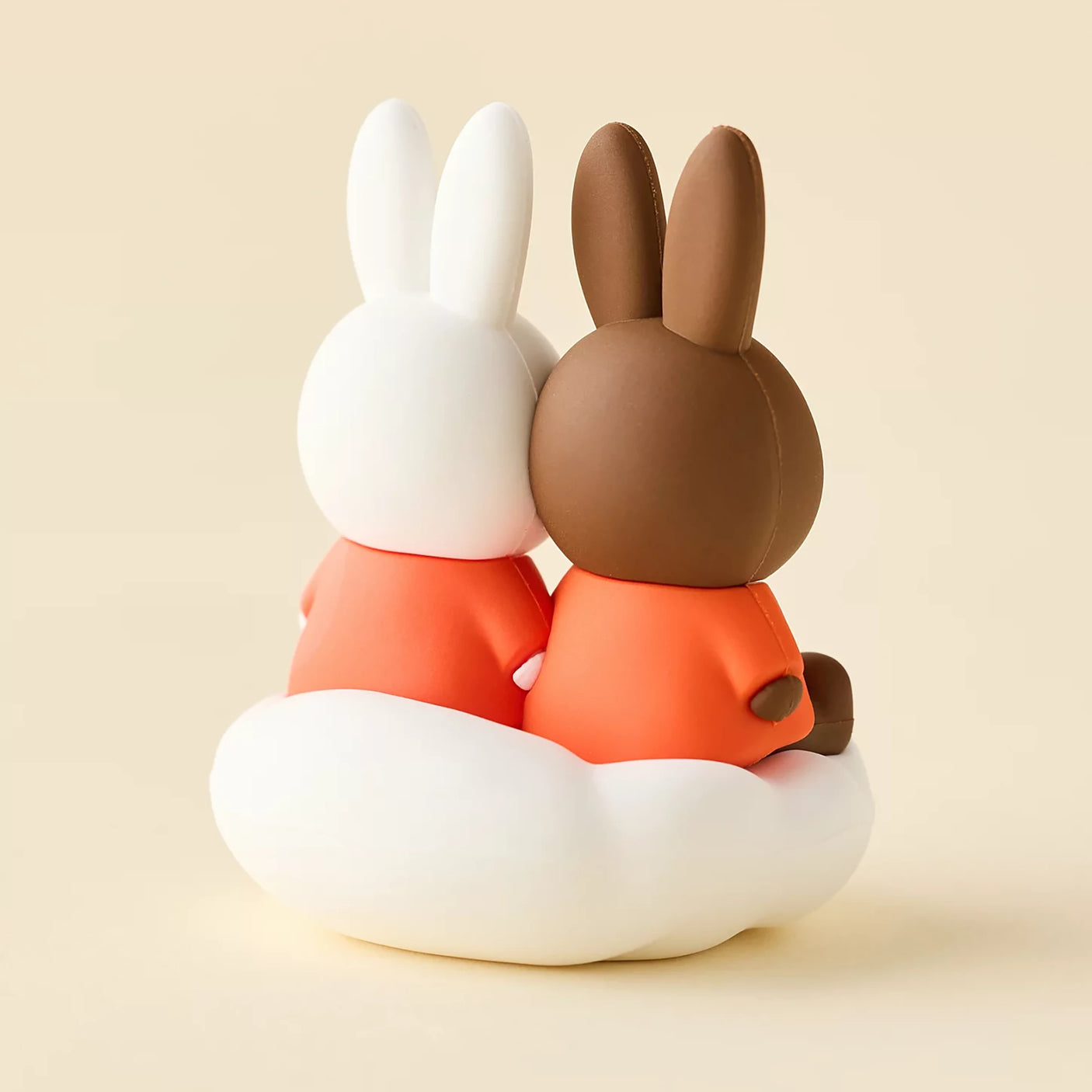 Rabbit blind box figures hugging on white cloud base, orange outfits