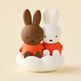 Rabbit blind box figures sitting together on white cloud base with orange outfits