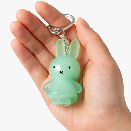 Mint green jelly rabbit keychain with metal ring and clasp, held in hand