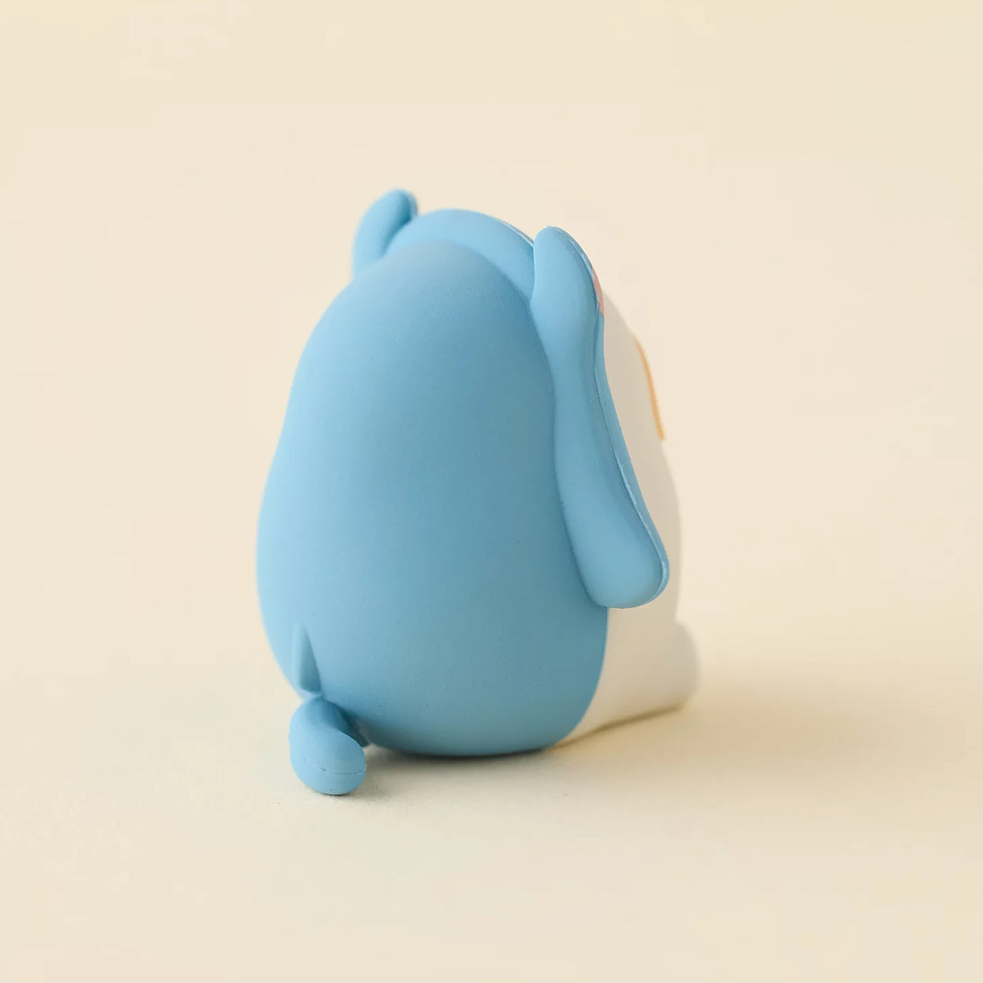Blue mini blind box figure with rounded body and small feet, side view