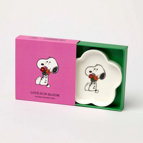 Cream flower-shaped dish with Snoopy holding flowers, in a colorful gift box