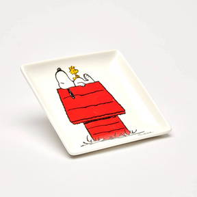 White square trinket dish tray with Snoopy and Woodstock illustration on red blanket