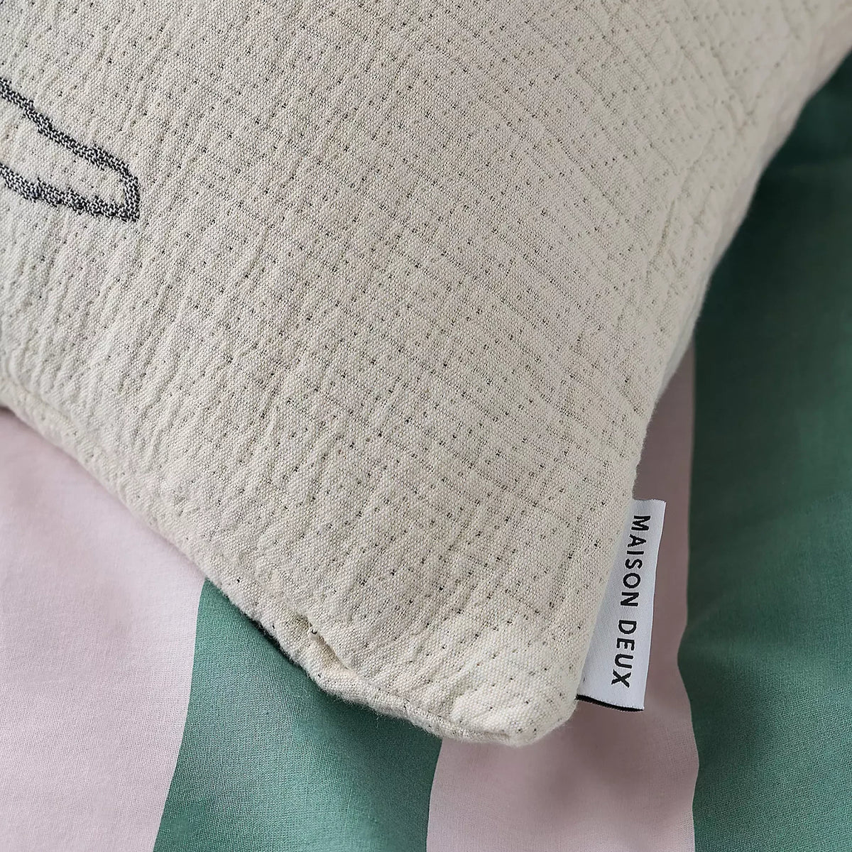Cream cotton cushion cover corner with stitched label reading MASON DEXUS