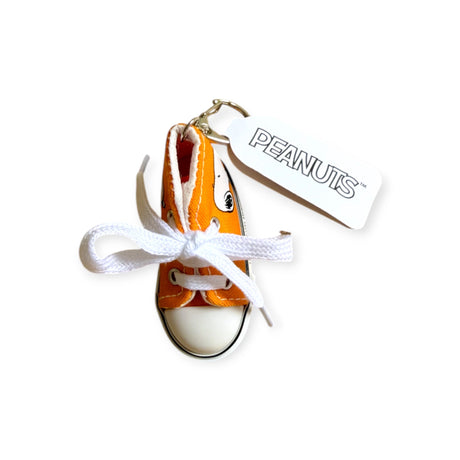 The Snoopy Orange Kicks Keychain is an adorable mini sneaker with white laces and a "Peanuts" tag, perfect for Peanuts fans and collectors.