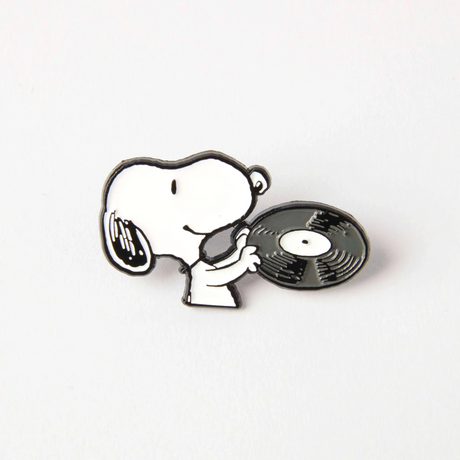 Enamel pin featuring Snoopy holding a vinyl record and earbuds