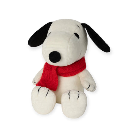 The Snoopy Scarf Plush - 17cm, crafted by Bon Ton Toys, sits upright with black ears and a red scarf, featuring a simple facial expression. Made from recycled polyester, it combines charm with sustainability.