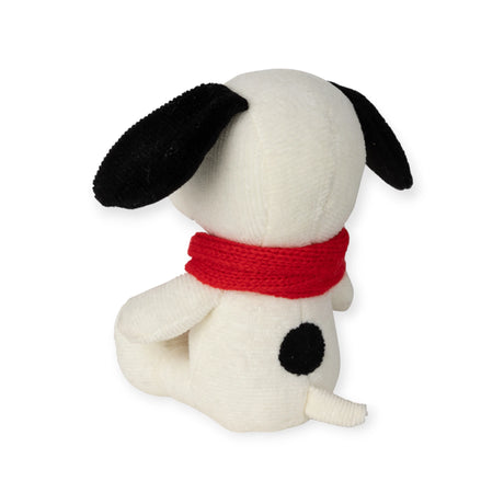 This adorable 17cm Snoopy Scarf Plush by Snoopy, crafted from recycled polyester, features a white dog with black ears and a black spot on its back, donning a red scarf while sitting gracefully and facing away.