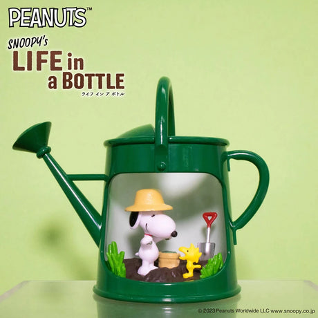 Green watering can diorama with Snoopy in farmer hat and Woodstock holding tiny shovel in garden scene