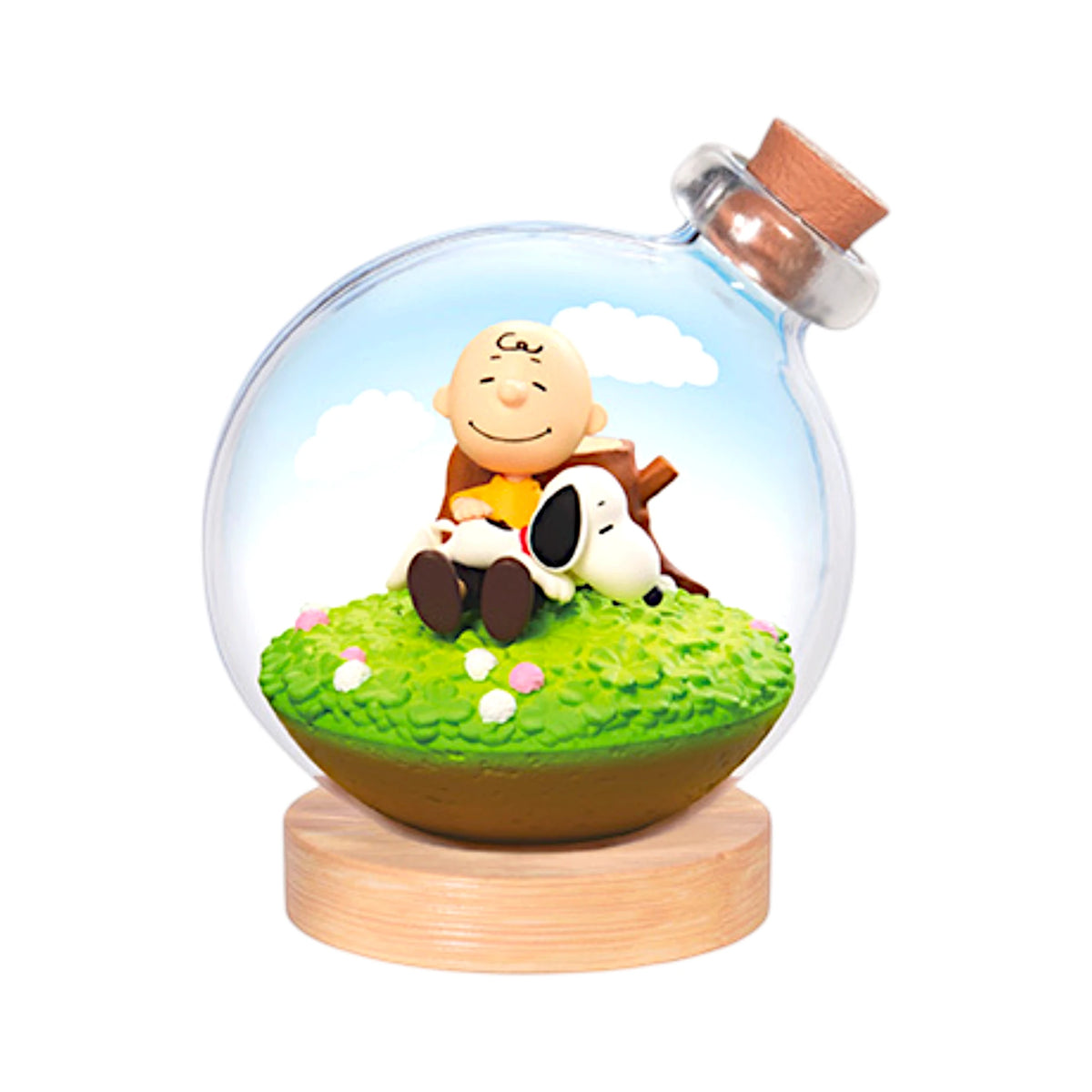Glass terrarium with Snoopy on green grass and bottle stopper, on wooden base