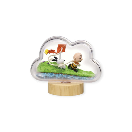 The Snoopy Blind Box - Weather Terrarium by Re-Ment showcases a cloud-shaped sculpture with Snoopy, the iconic white dog from the Peanuts Collection, as a character flies a red kite beside him on a grassy base. This delightful scene is enclosed in clear material with a wooden stand, creating an enchanting display of captured joy.